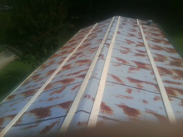 Rusted metal roof panels with new wood purlins before replacement — Storm Damage Roof Repair in White Lake by Roofing Brothers